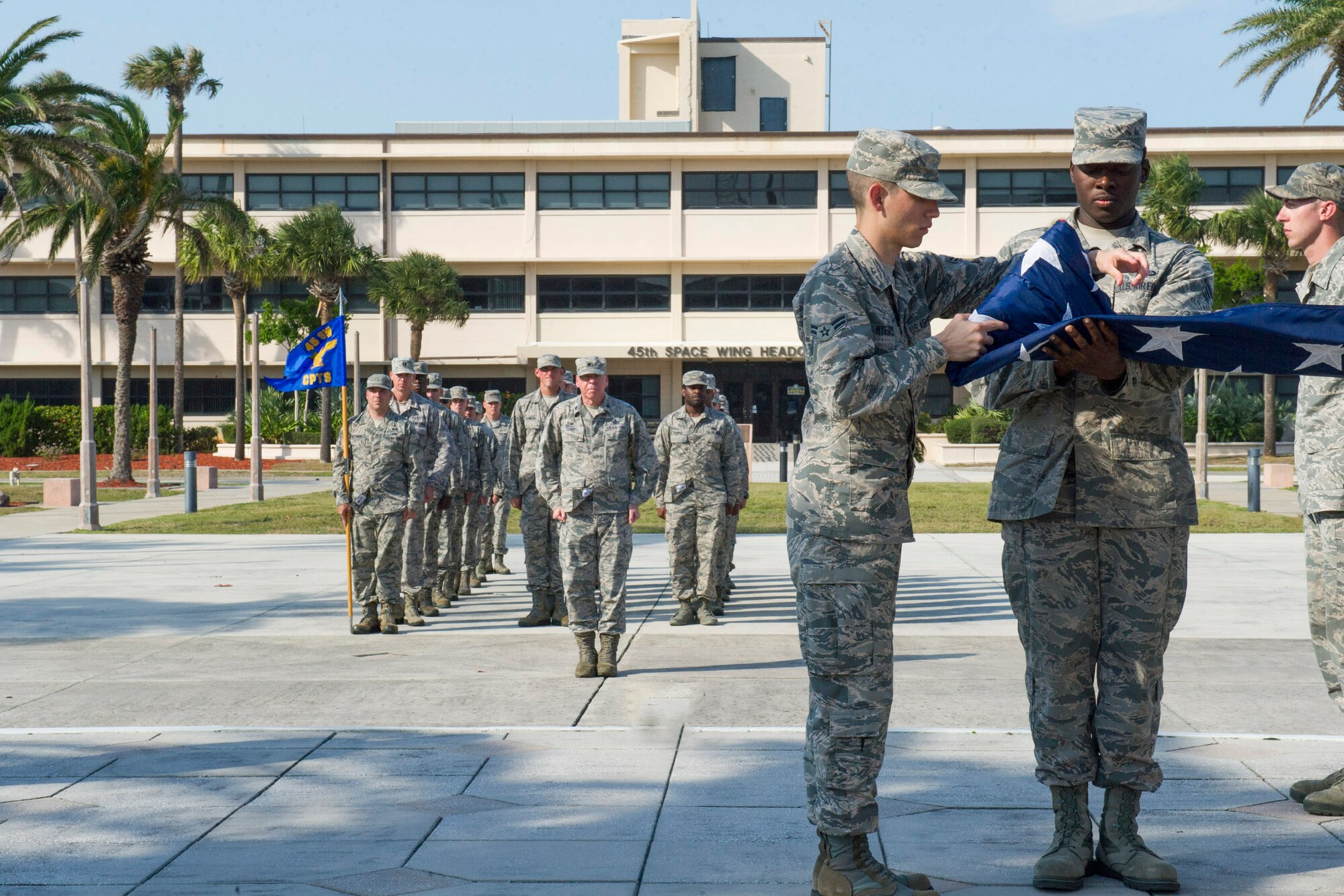 Airmen fold the flag as 45th Space Wing members stand in formation during a wing retreat April 5, 2017, at Patrick Air Force Base, Fla. The wing holds retreat quarterly to show its respect to the Stars and Stripes. (U.S. Air Force Photo by Phil Sunkel) 