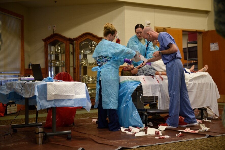 Maj. Hans Watson, emergency room doctor, checks for signs of life on drunken driving victim while Tech. Sgt. Lauren Pelkey uses a handheld resuscitator and Airman 1st Class Yolanda Alvarez Hernandez performs chest compressions April 12, 2017, at the Grizzly Bend at Malmstrom Air Force Base, Mont. The event was part of “Live or Die,” a production helping members think about consequences before they get behind the wheel intoxicated. (U.S. Air Force photo\ Staff Sgt. Lindsey Soulsby)