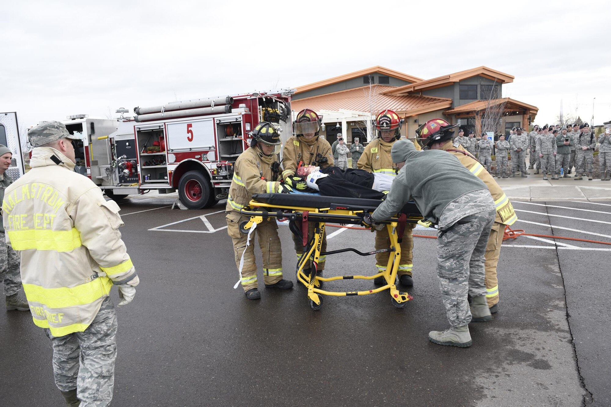 Malmstrom Airmen watch as firefighters transfer an Airman acting as a drunken driving victim to a gurney April 12, 2017, at the Grizzly Bend at Malmstrom Air Force Base, Mont. The event was part of “Live or Die,” a production helping members think about consequences before they get behind the wheel intoxicated. (U.S. Air Force photo\ Staff Sgt. Lindsey Soulsby)