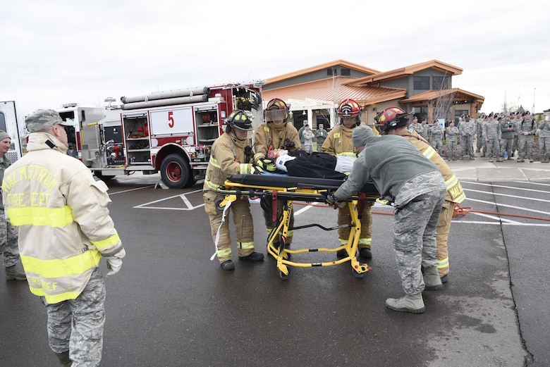 Malmstrom Airmen watch as firefighters transfer an Airman acting as a drunken driving victim to a gurney April 12, 2017, at the Grizzly Bend at Malmstrom Air Force Base, Mont. The event was part of “Live or Die,” a production helping members think about consequences before they get behind the wheel intoxicated. (U.S. Air Force photo\ Staff Sgt. Lindsey Soulsby)