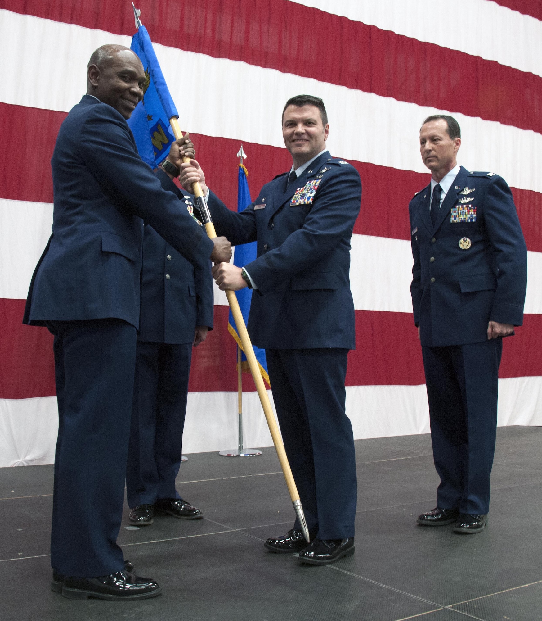 Brig. Gen. Ondra Berry, the Asst. Adjutant General of Nevada Air National Guard, Reno, Nev. passes the flag, and command, of the 152nd Airlift Wing to the new commander, Col. Eric Wade. Col. Karl Stark (far right), the outgoing commander relinquished command of the 152nd Airlift Wing on April 1, 2017.