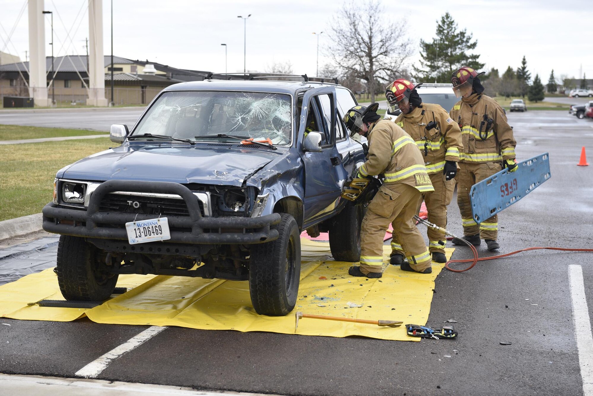 Firefighters use a hydraulic rescue tool to remove an Airman acting as a drunken driving victim from a vehicle April 12, 2017, at the Grizzly Bend at Malmstrom Air Force Base, Mont. The event was part of “Live or Die,” a production helping members think about consequences before they get behind the wheel intoxicated. (U.S. Air Force photo\ Staff Sgt. Lindsey Soulsby) 