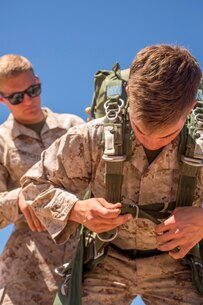 U.S. Marine Lance Cpl. Connor Honeycutt assists Lance Cpl. Avery Wells with adjusting his parachute during Weapons and Tactics Instructors Course 2-17 on Marine Corps Air Station, Yuma, Ariz., March 30, 2017. Static line parachute training is used to develop Marines’ efficiency with the equipment. Honeycutt is an air delivery specialist with Landing Support Company, 1st Transportation Support Battalion, Combat Logistics Regiment 1, 1st Marine Logistics Group and Wells is an air delivery specialist with Landing Support Company, 1st TSB, CLR-1, 1st MLG. (U.S. Marine Corps photo by Lance Cpl. Roderick Jacquote)