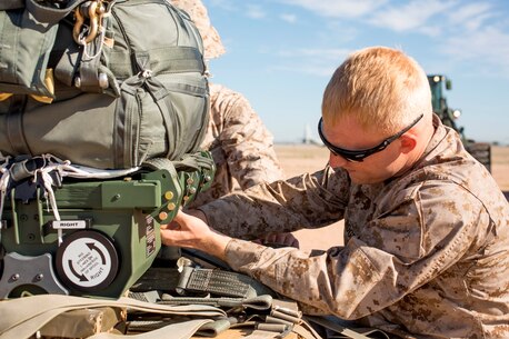 U.S. Marine Lance Cpl. Chancy Rogers adjusts the settings on a Joint Precision Airdrop System during Weapons and Tactics Instructors Course 2-17 on Marine Corps Air Station, Yuma, Ariz., March 30, 2017. The JPADS uses GPS, a modular autonomous guidance unit, a parachute and electric motors to guide cargo to their targeted drop zones. Rogers is an air delivery specialist with Landing Support Company, 2nd Transportation Support Battalion, 2nd Combat Logistics Regiment, 2nd Marine Logistics Group. (U.S. Marine Corps photo by Lance Cpl. Roderick Jacquote)