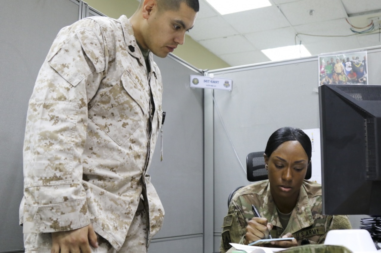 Army Sgt. Bryttany Gant, an awards noncommissioned officer for Combined Joint Task Force Operation Inherent Resolve, assists Marine Corps Gunnery Sgt. Carlos Perez at Camp Arifjan, Kuwait, March 25, 2017. Gant’s professionalism and motivation have earned her chain of command’s support to apply for Officer Candidate School. Army photo by Sgt. Bethany Huff