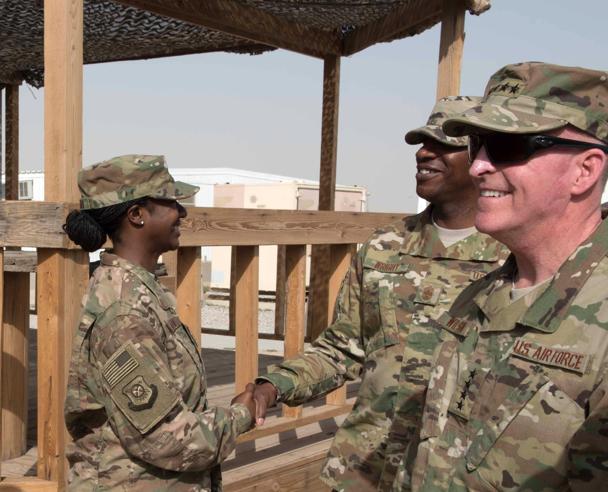 Deployed Team Vance member, Master Sgt. Canadra Tillman (left) receives a coin and handshake from Chief Master Sgt. of the Air Force Kaleth Wright, during his and (in foreground) Air Force Vice Chief of Staff Gen. Stephen Wilson’s visit to Tillman’s location. (U.S. Air Force photo/Master Sgt. Benjamin Wilson)
