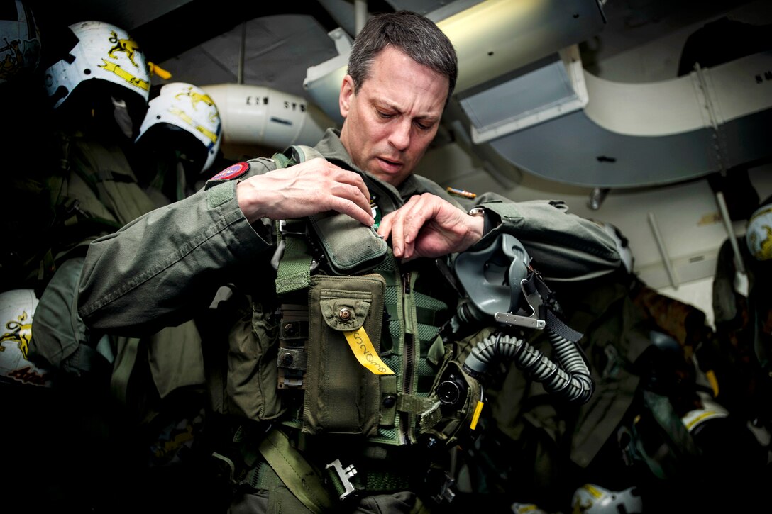 Navy Capt. Paul C. Spedero Jr., commander of the USS Dwight D. Eisenhower, dons flight gear aboard the aircraft carrier in the Atlantic Ocean, April 2, 2017. The ship and its carrier strike group are underway conducting a sustainment exercise to support the Optimized Fleet Response Plan. Navy photo by Seaman Zachary A. Sleeper
