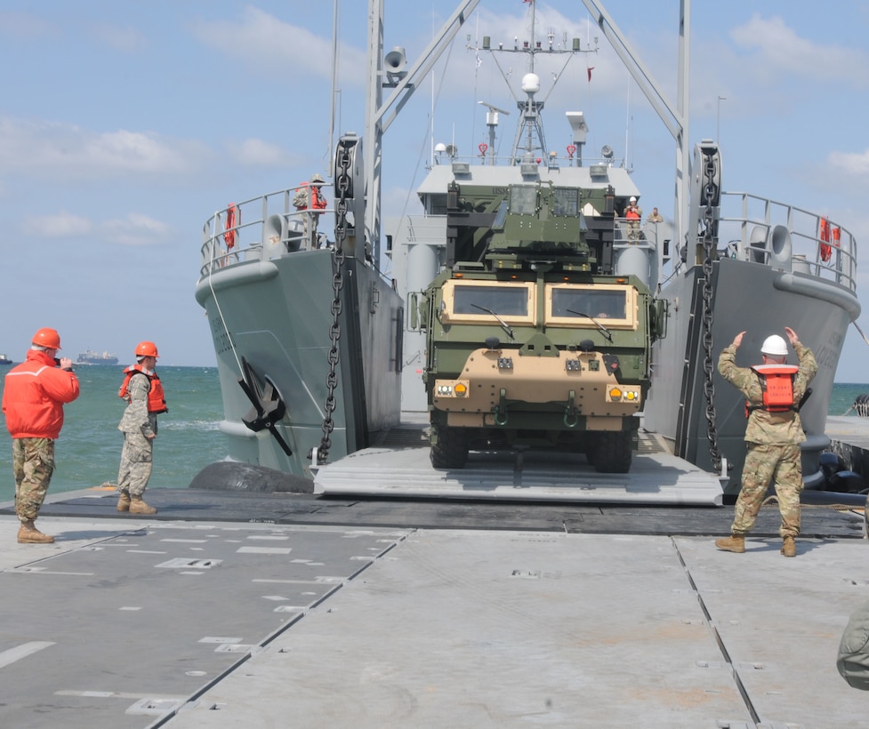 A Marine attached to Marine Air Control Battalion 4 guides a tactical vehicle as it is unloaded from an Army landing craft utility ship onto the Trident Pier during Operation Pacific Reach 2017 at Pohang, South Korea, April 10, 2017. Army photo by Sgt. Quanesha Deloach