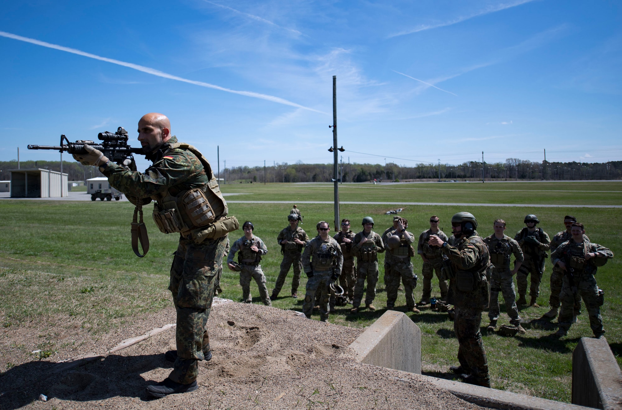 German Air Force Maj. Nader Samadi, German Air Ground Operations Squadron commander demonstrates the different stances Airmen must shoot from to successfully complete the shooting portion of a German armed forces proficiency assessment, April 4, 2017, at Fort Campbell, Ky. To enhance their ability to work together in deployed locations, members of the German Air Force travelled to Fort Campbell to train and exercise with the 19th ASOS. While at Fort Campbell, The German Air Force members hosted a German armed forces proficiency assessment for Airmen consisting of shooting firearms, swimming, agility exercises and a rucksack march.