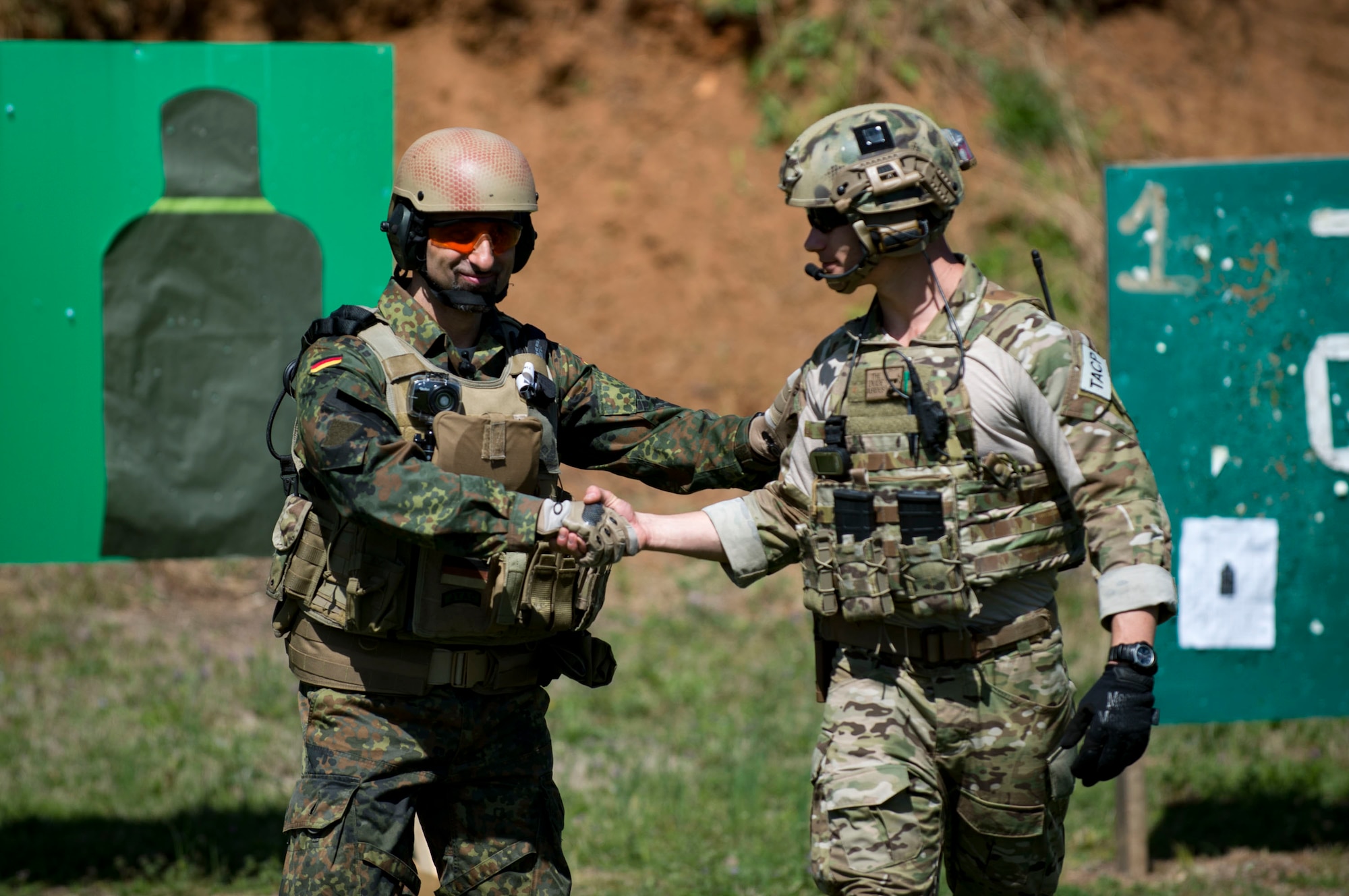 German Air Force Maj. Nader Samadi, German Air Ground Operations Squadron commander left, congratulates U.S. Air Force Ryan Hawkins 19th Air Ground Operations Squadron Tactical Air Control Party specialist, during the shooting portion of a German armed forces proficiency assessment, April 4, 2017, at Fort Campbell, Ky. To enhance their ability to work together in deployed locations, members of the German Air Force travelled to Fort Campbell to train and exercise with the 19th ASOS. While at Fort Campbell, The German Air Force members hosted a German armed forces proficiency assessment for Airmen consisting of shooting firearms, swimming, agility exercises and a rucksack march.