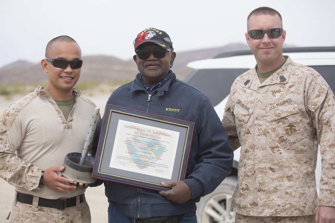 Capt. Christopher J. Silva, inspector-instructor, and Master Sgt. Ryan Barbour, tank leader, of Company D, 4th Tank Battalion, presented a plaque to retired U.S. Marine Corps Staff Sgt. Kenneth R. White at Range 500 during a visit to Marine Corps Air Ground Combat Center, Twentynine Palms, Calif., Sunday. 4th Tanks invited White aboard the Combat Center because they wanted to honor his last wish as a former tanker. (U.S. Marine photo by Lance Cpl. Natalia Cuevas)