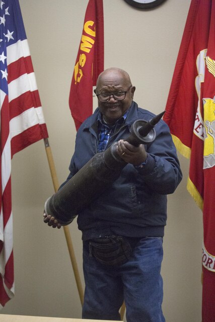 Retired U.S. Marine Corps Staff Sgt. Kenneth R. White, 82, holds a simulated 120mm tank round at the 4th Tank Battalion command post during a visit to Marine Corps Air Ground Combat Center, Twentynine Palms, Calif., Sunday. 4th Tanks invited White aboard the Combat Center because they wanted to honor his last wish as a former tanker. (U.S. Marine photo by Lance Cpl. Natalia Cuevas)