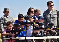 Airmen watch over children of members from the 944th Fighter Wing as they fire paint balls Apr. 1 during Operation Reserve Kids at Luke Air Force Base, Ariz. (U.S. Air Force photo by Tech. Sgt. Louis Vega Jr.)