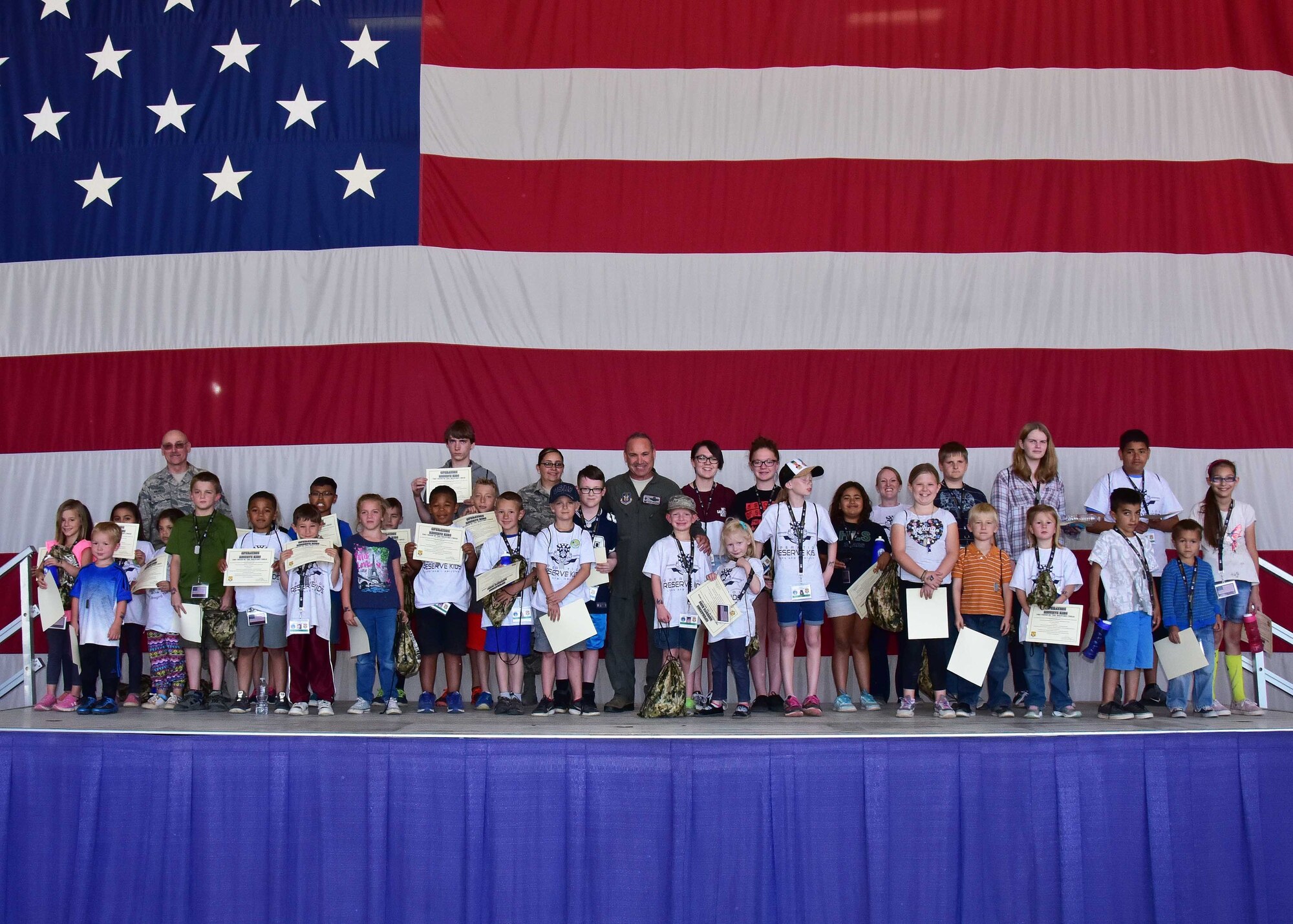 Children of members form the 944th Fighter Wing pose for a photo with Col. Kurt Gallegos, 944 FW commander, during Operation Reserve Kids at Luke Air Force Base, Ariz. (U.S. Air Force photo by Tech. Sgt. Louis Vega Jr.)