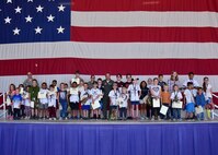 Children of members form the 944th Fighter Wing pose for a photo with Col. Kurt Gallegos, 944 FW commander, during Operation Reserve Kids at Luke Air Force Base, Ariz. (U.S. Air Force photo by Tech. Sgt. Louis Vega Jr.)
