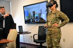Maj. Jean Williams, right, Medical Education Training Campus Department of Combat Medic Training branch chief, participates in a demonstration of the Virtual Education System under the direction of Robert Moore, CEO of Virtual Education Systems, at Heritage Hall at Joint Base San Antonio-Fort Sam Houston April 1. VES is a virtual reality based training platform in which the learner interacts with a virtual patient in various situations, including at a home, an ambulance and a hospital room.