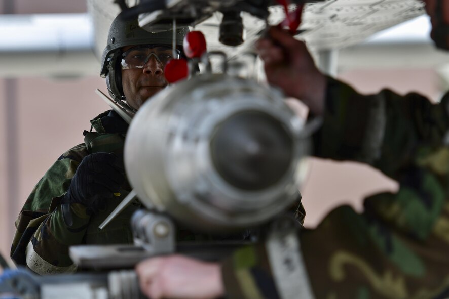 U.S. Air Force Senior Airman Cesar Otero-Moya, 25th Aircraft Maintenance Unit 2-man, helps guide a GBU-38 laser-guided bomb into position during the 51st Maintenance Group weapons load crew of the quarter competition at Osan Air Base, Republic of Korea, April 14, 2017. The top weapons load crew from the 25th and 36th AMUs and the New Jersey Air National Guard’s 177th Aircraft Maintenance Squadron competed to see who could arm their respective aircraft the quickest, most efficient and safest. (U.S. Air Force photo by Staff Sgt. Victor J. Caputo)