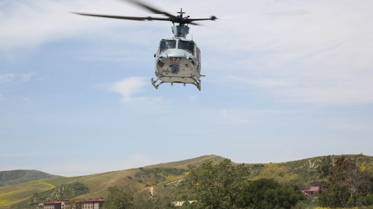 A UH-1Y Huey with Marine Light Attack Helicopter Training Squadron 303 flies over Marines with School of Infantry West during an aerial demonstration at Marine Corps Base Camp Pendleton, Calif., April 11. Marines with HMLAT-303 conducted basic flight maneuvers during the demonstration to build cohesion between air and ground Marines. 