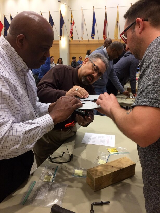 Employees from the DLA Troop Support Industrial Hardware supply chain participate in a Cross Function Day activity in the Bldg. 6 auditorium April 6. Personnel worked in small teams to construct military service insignia with hardware managed by the IH supply chain. The Cross Function Day event was designed to boost information-sharing across the supply chain’s diverse units and functions. 