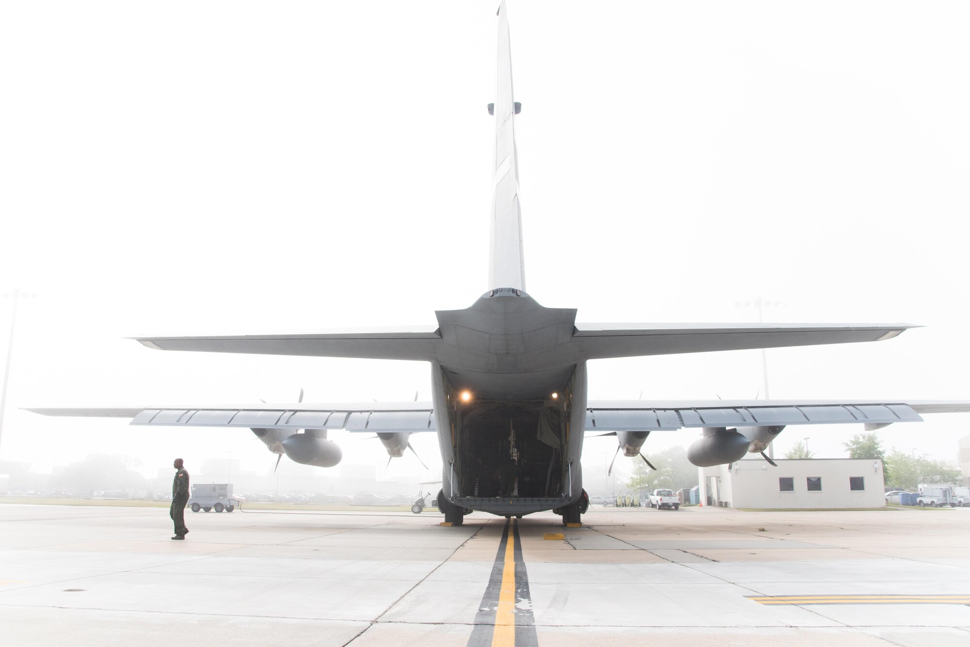 Master Sgt. Troy Bickham walks toward equipment to be loaded onto a WC-130J Super Hercules aircraft on a foggy morning April 12 at Keesler Air Force Base, Mississippi. (U.S. Air Force photo/Staff Sgt. Heather Heiney)