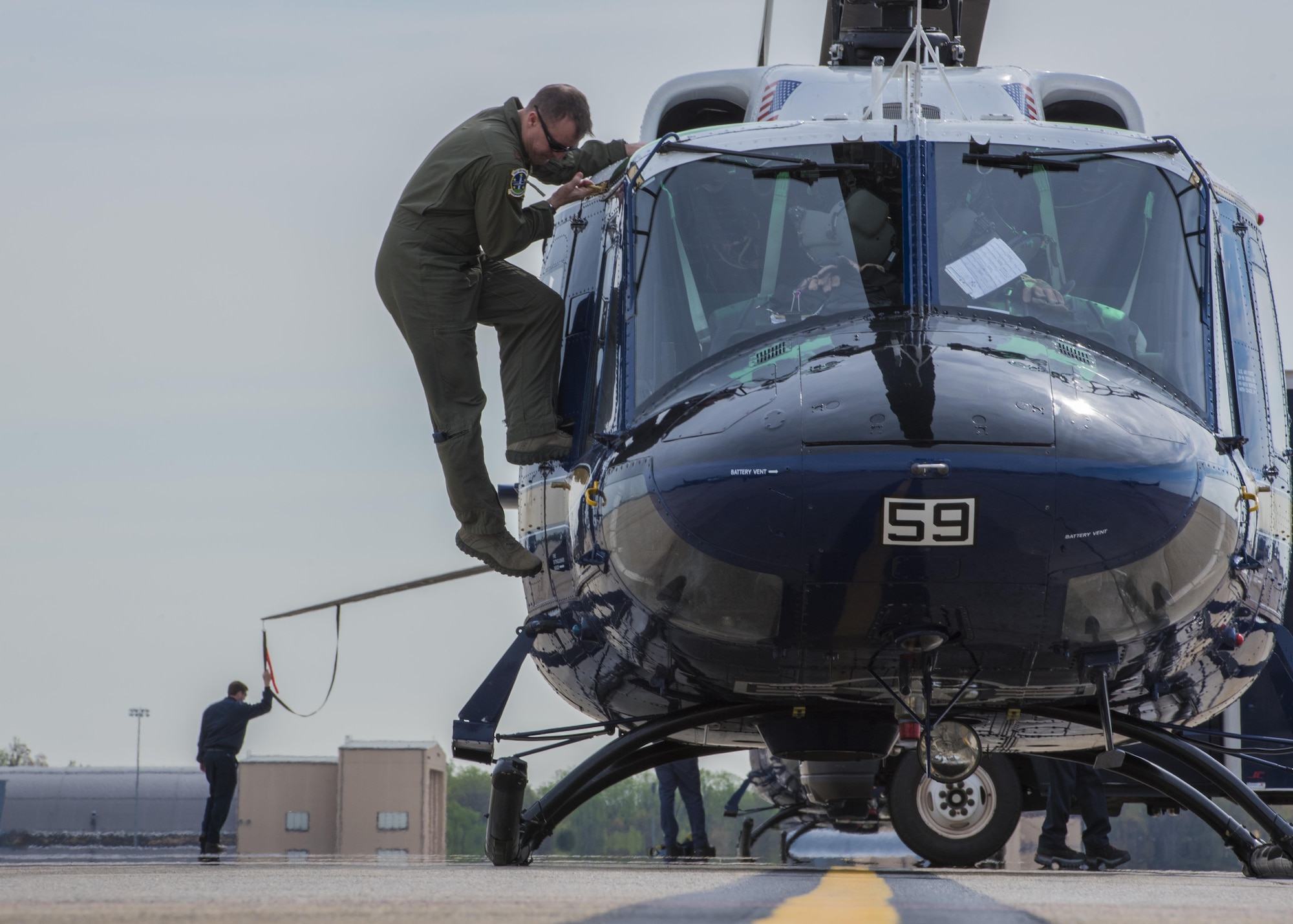 An UH-1N Iroquois pilot climbs off a helicopter after a flight at Joint Base Andrews, Md., April 13, 2017. The aircraft belong to the 1st Helicopter Squadron, which conducts high-priority airlift missions and provides contingency response in the National Capitol Region. The squadron performed a medical evacuation of a downed pilot during the F-16 Fighting Falcon crash incident April 5.  (U.S. Air Force photo by Senior Airman Jordyn Fetter)