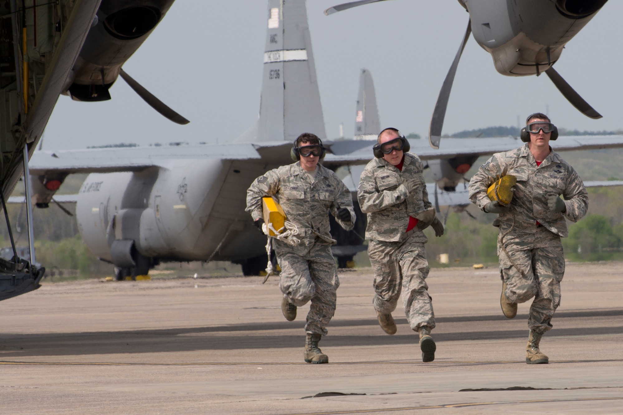 (Left to Right) U.S. Air Force Reserve Tech Sgt. Danny Canup, Tech Sgt. Jason Gibson and Master Sgt. Morgan Abner scramble for the finish line to stop the clock, after unloading a C-130J Super Hercules April 2, 2017, at Little Rock Air Force Base, Ark. The Airmen, are assigned to the 96th Aerial Port Squadron, were practicing for the 2017 Port Dawg Challenge to be held at Dobbins Air Reserve Base, Ga. (U.S. Air Force photo by Master Sgt. Jeff Walston/Released)