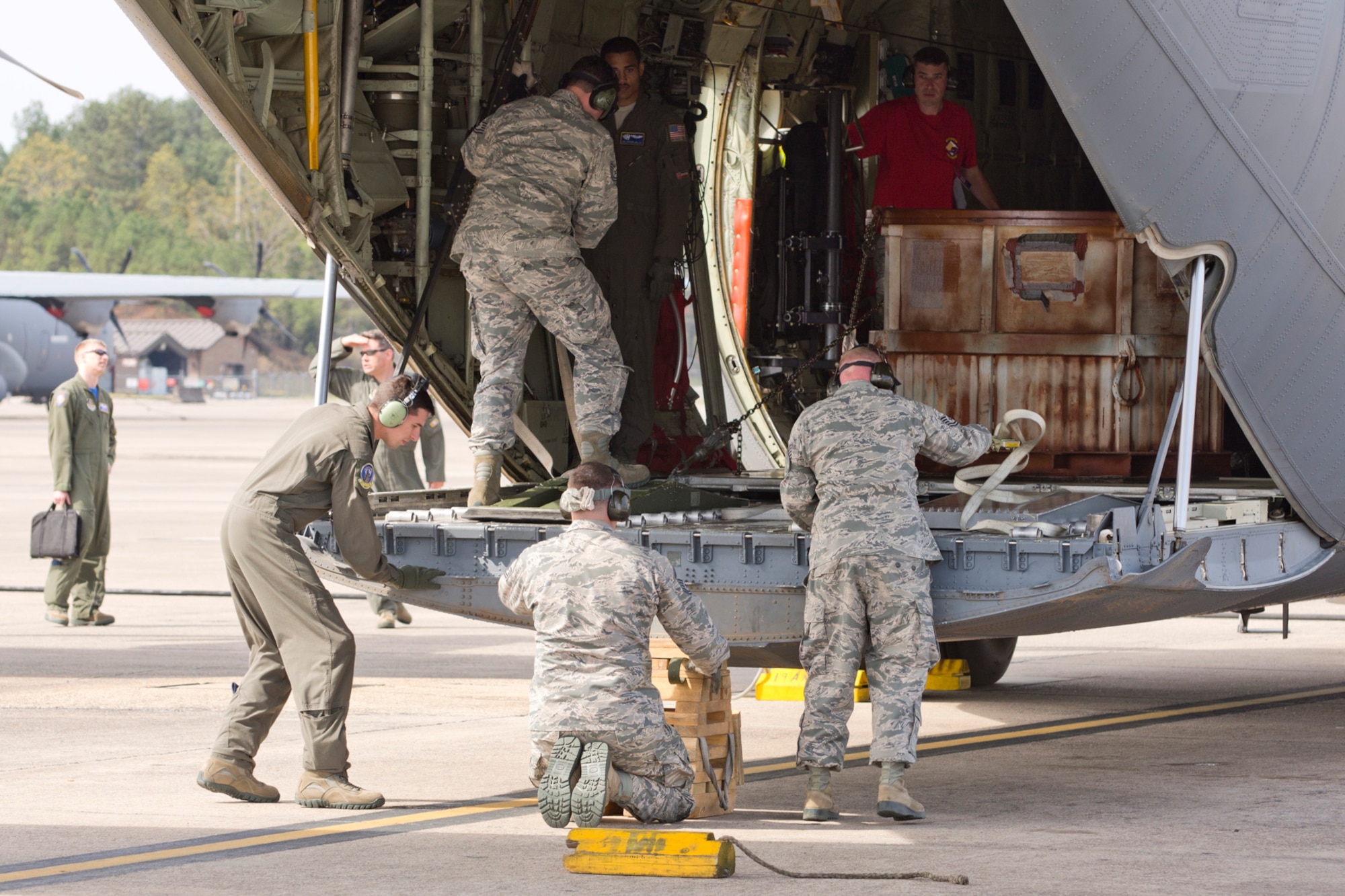 (Left to Right) A competition team assigned to the 96th Aerial Port Squadron unload the C-130J Super Hercules, they just loaded, during a training exercised April 2, 2017, at Little Rock Air Force Base, Ark. The Airmen are preparing for the 2017 Port Dawg Challenge for air mobility professionals, that is being held at Dobbins Air Reserve Base, Ga. (U.S. Air Force photo by Master Sgt. Jeff Walston/Released)