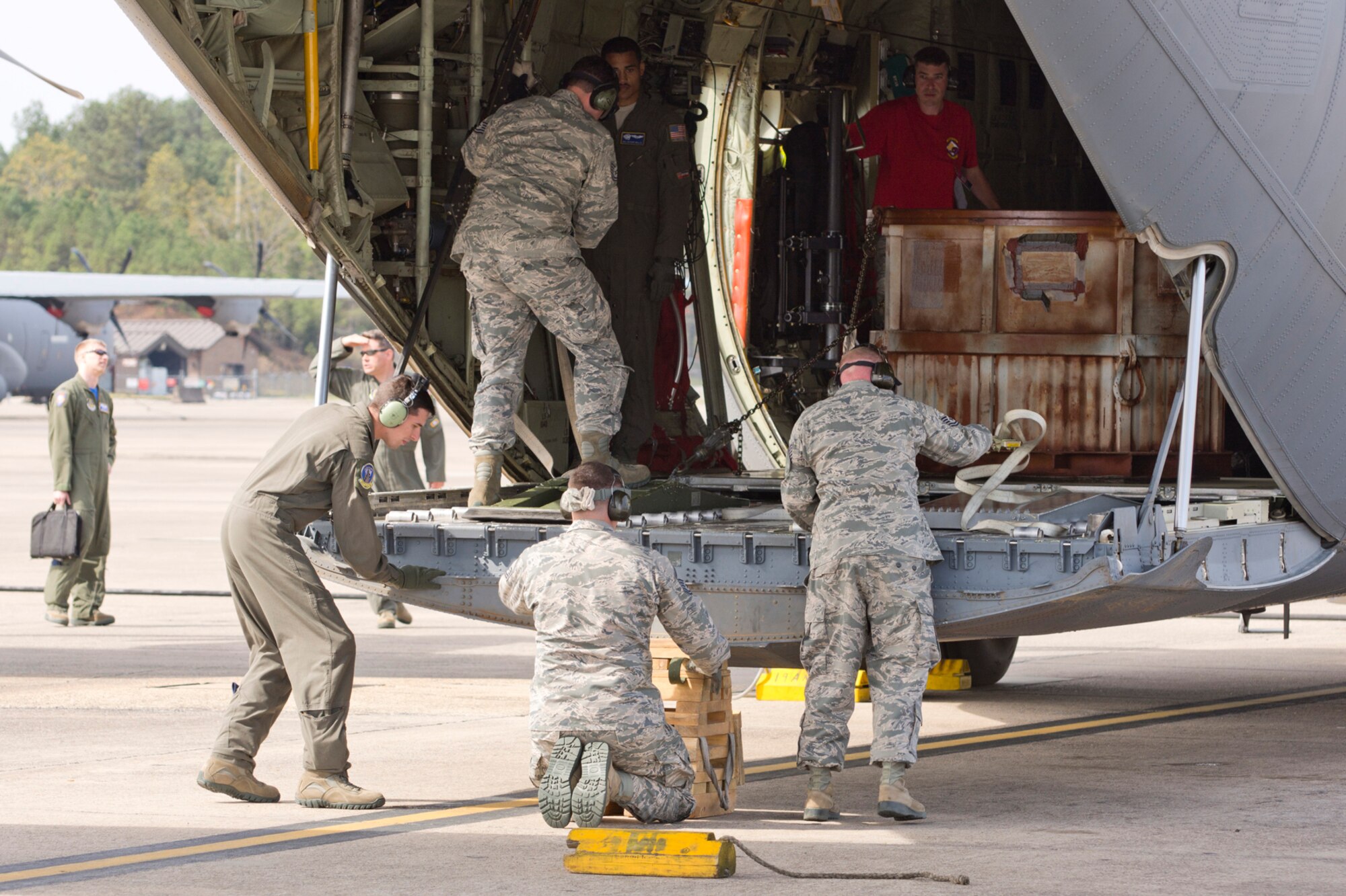 (Left to Right) A competition team assigned to the 96th Aerial Port Squadron unload the C-130J Super Hercules, they just loaded, during a training exercised April 2, 2017, at Little Rock Air Force Base, Ark. The Airmen are preparing for the 2017 Port Dawg Challenge for air mobility professionals, that is being held at Dobbins Air Reserve Base, Ga. (U.S. Air Force photo by Master Sgt. Jeff Walston/Released)