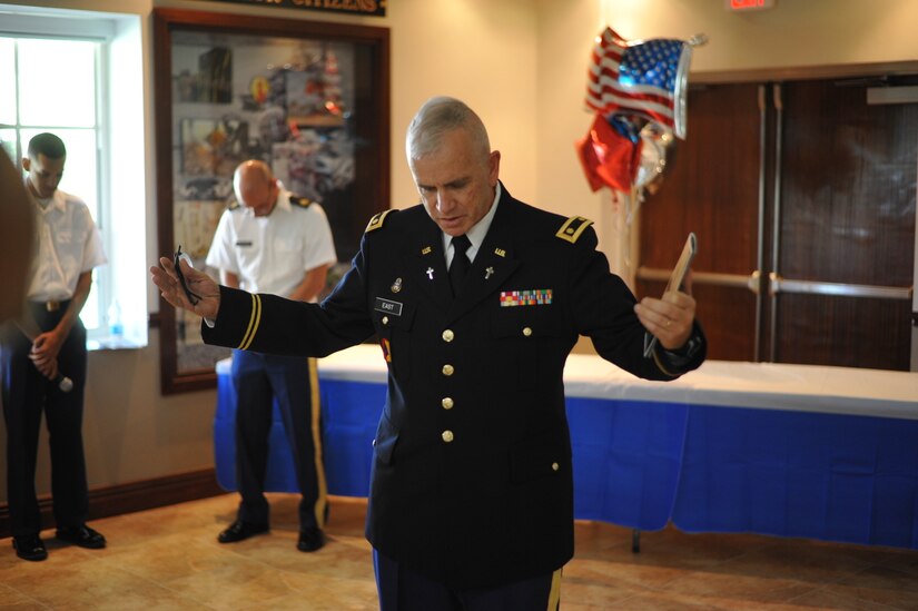 Chaplain (Major) Mark East, 1st MSC Deputy Command Chaplain, prays for all the retirees and their families during a retirement ceremony held at Ramon Hall on Fort Buchanan, April 8.