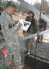 Master Sgt. William Buttrey records competitor Staff Sgt. Marcy DiOssi's weapons score at the 9mm pistol range at Fort Devens, Massachusetts, April 4, 2017, as part of the 2017 Joint 80th Training Command and 99th Regional Support Command Best Warrior Competition.