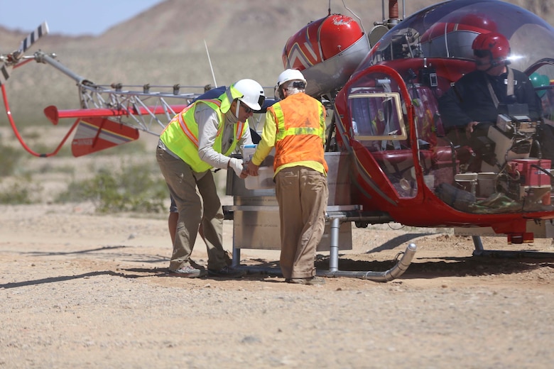 Employees from Natural Resources and Environmental Affairs, remove empty bins for desert tortoises from a helicopter during the Desert Tortoise translocation, April 10, 2017, which was facilitated by the Marine Corps Air Ground Combat Center, Twentynine Palms, Calif. The translocation, in accordance with the U.S. Fish and Wildlife Service-signed Biological Opinion, serves as a negotiated mitigation to support a congressionally mandated land expansion which, will afford the Combat Center the ability to conduct Large Scale Exercise training of a Marine Expeditionary Brigade-level force. (U.S. Marine Corps photo by Cpl. Medina Ayala-Lo)