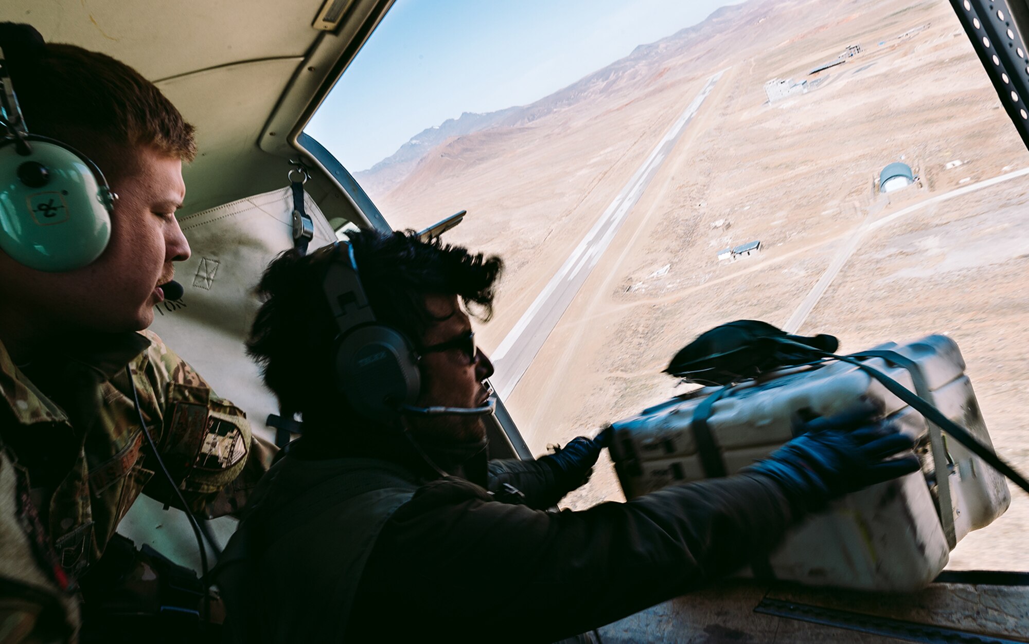 An Afghan Air Force member training with Train, Advise, Assist Command-Air, as part of Resolute Support Mission, works in tandem with an advisor to practice air drops near Kabul, Afghanistan, March 19, 2017. The TAAC-Air advisors foster working relationships and fortify confidence in the mission. (U.S. Air Force photo by Senior Airman Jordan Castelan)