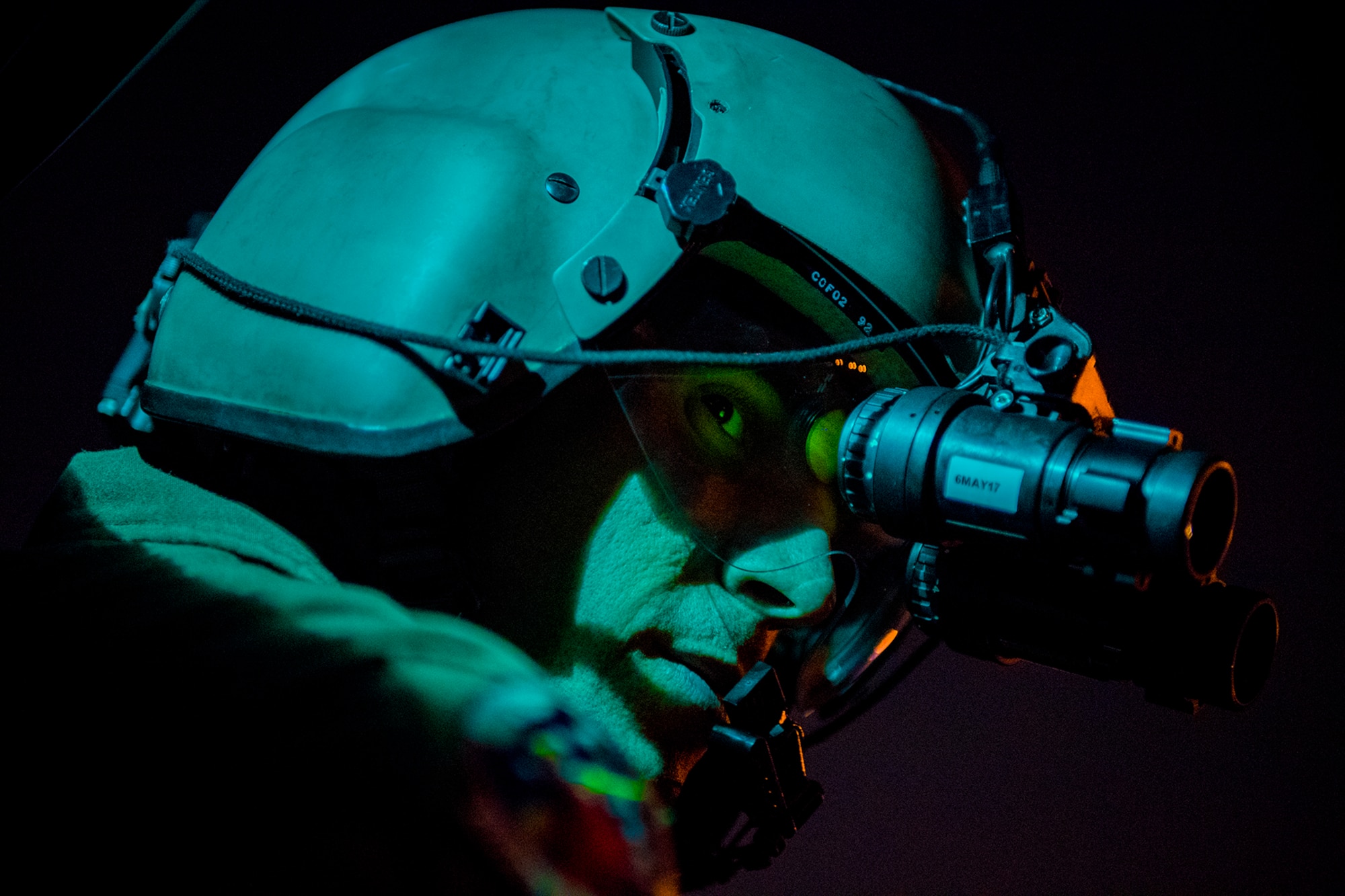 Staff Sgt. Nicholas A. Poe, a 459th Airlift Squadron special missions aviator, looks out the window of a UH-N1 Iroquois, through night vision goggles, during a night hoist training exercise April 4, 2017, in Tokyo. The aircrew trained with night vision goggles to prepare for missions that must be conducted at night. (U.S. Air Force photo/Airman 1st Class Donald Hudson)
