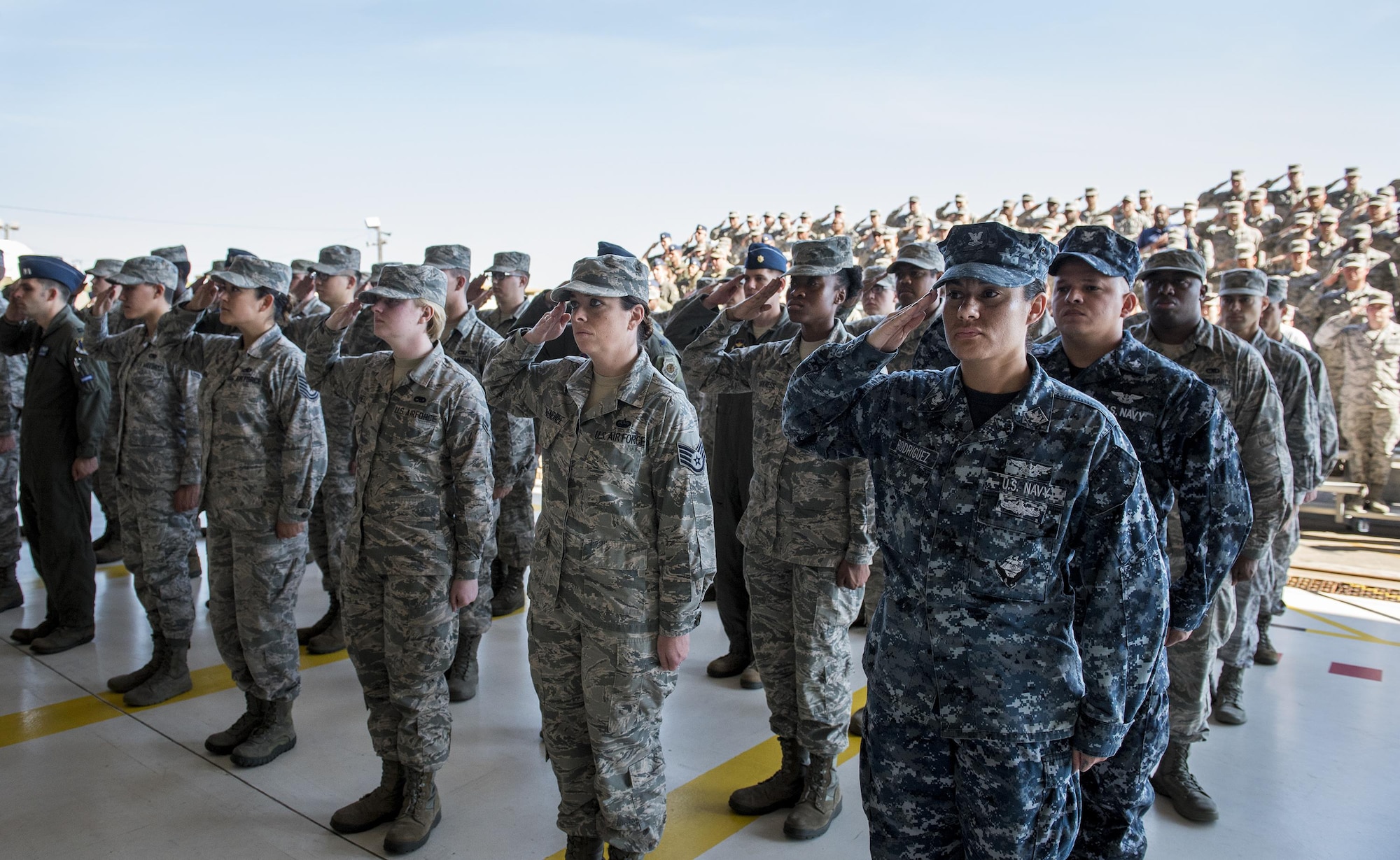 Airmen and Sailors salute during the national anthem at the 33rd Fighter Wing’s change of command ceremony at Eglin Air Force Base, Fla., April 13.  The Navy was represented at the ceremony due to its working relationship with the 33rd FW and the joint strike fighter.  Col. Lance Pilch relinquished command of the training wing to Col. Paul Moga.  (U.S. Air Force photo/Samuel King Jr.)