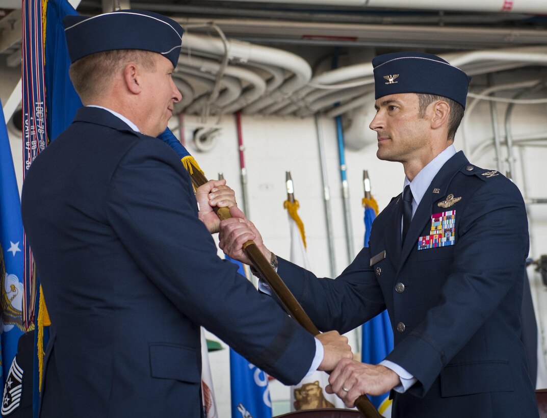 Col. Paul Moga accepts the 33rd Fighter Wing guidon during the wing’s change of command ceremony at Eglin Air Force Base, Fla., April 13.  Col. Lance Pilch relinquished command of the training wing to Moga.  (U.S. Air Force photo/Samuel King Jr.)