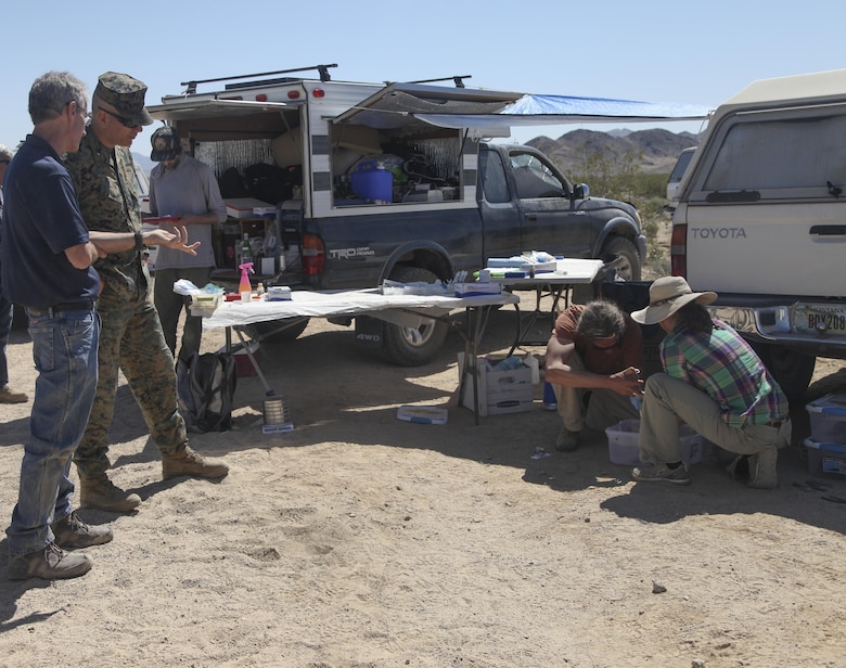 Commanding General, Brig. Gen. William F. Mullen III, observes as a desert tortoise receives a health assessment, April 12, 2017, during the desert tortoise translocation aboard the Marine Corps Air Ground Combat Center, Twentynine Palms, Calif. The translocation, in accordance with the U.S. Fish and Wildlife Service-signed Biological Opinion, serves as a negotiated mitigation to support the mandated land expansion which will afford the Combat Center the ability to conduct Large Scale Exercise training featuring up to a Marine Expeditionary Brigade-level force. (U.S. Marine Corps photo by Lance Cpl. Natalia Cuevas)