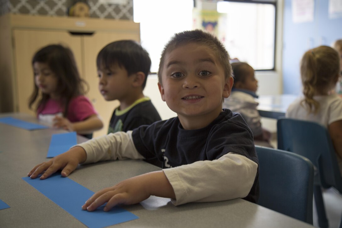 Children enjoy a family related craft at the Children's Development Center aboard Marine Corps Logistics Base Barstow, Calif., April 6. The staff assists the children with markers and stickers to make a representation of each child's family for a paper chain craft to be finished the next day.