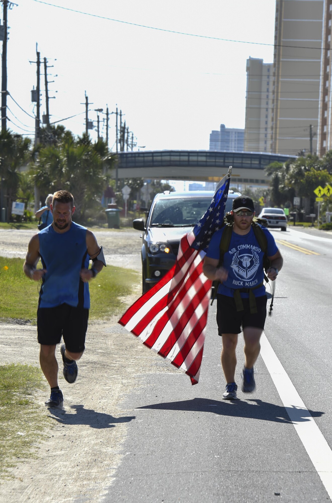 A local runner marches alongside Tech. Sgt. Doug Iredale, a special missions aviator with the 4th Special Operations Squadron, as part of the 6th Annual Air Commando Ruck March at Panama City Beach, Fla., April 13, 2017. The Air Commando Ruckers marched 450 miles from MacDill Air Force Base, to Hurlburt Field. (U.S. Air Force photo by Airman 1st Class Joseph Pick)