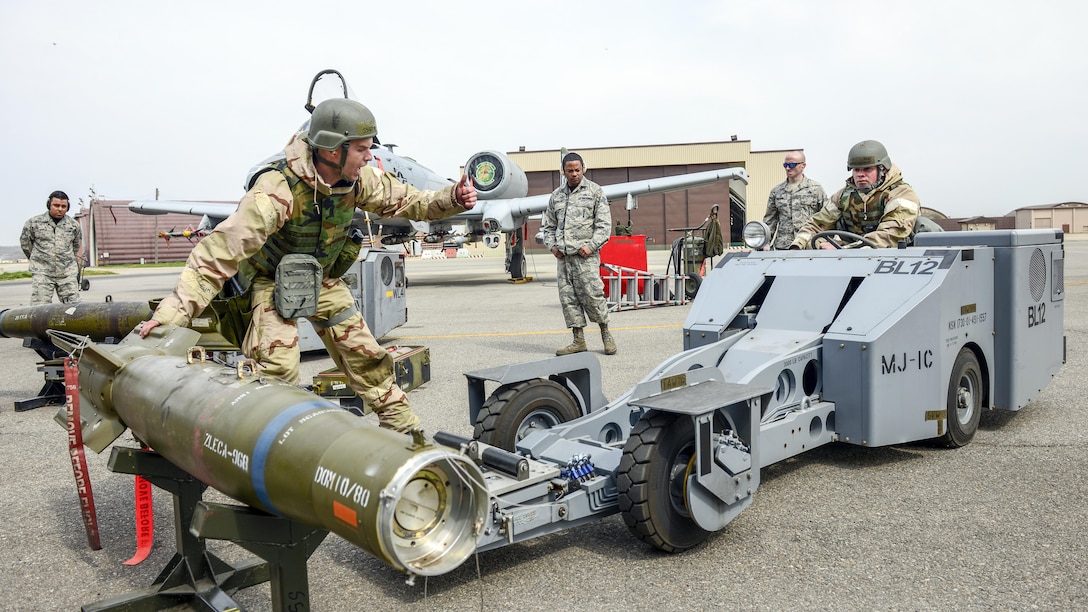 Air Force Staff Sgt. John Bybee guides Staff Sgt. Andrew Finnegan as they move a GBU-12 Paveway II bomb during a weapons load crew competition at Osan Air Base, South Korea, April 14, 2017. The airmen, assigned to the New Jersey Air National Guard's 177th Fighter Wing, competed against active-duty counterparts. Air Force photo by Staff Sgt. Victor J. Caputo
