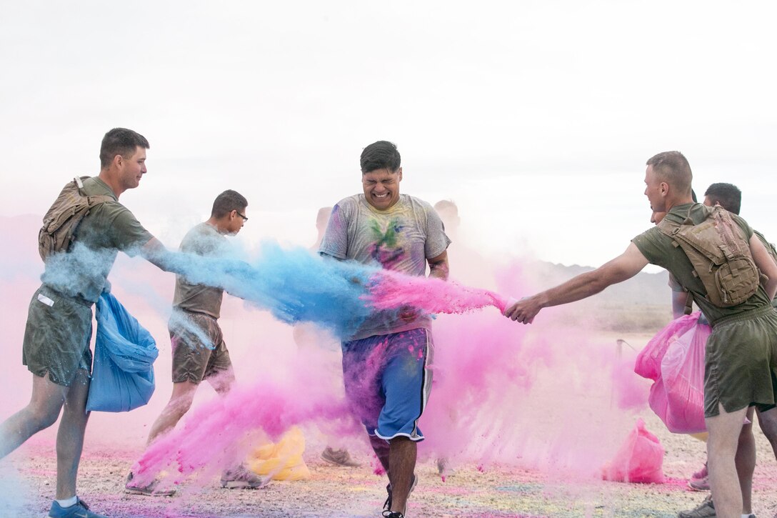 Marines throw colored powder onto participants of the annual Colorful Consent 5k Run to mark Sexual Assault Awareness and Prevention Month at Marine Corps Air Ground Combat Center Twentynine Palms, Calif., April 7, 2017. Marine Corps Photo by Cpl. Julio McGraw