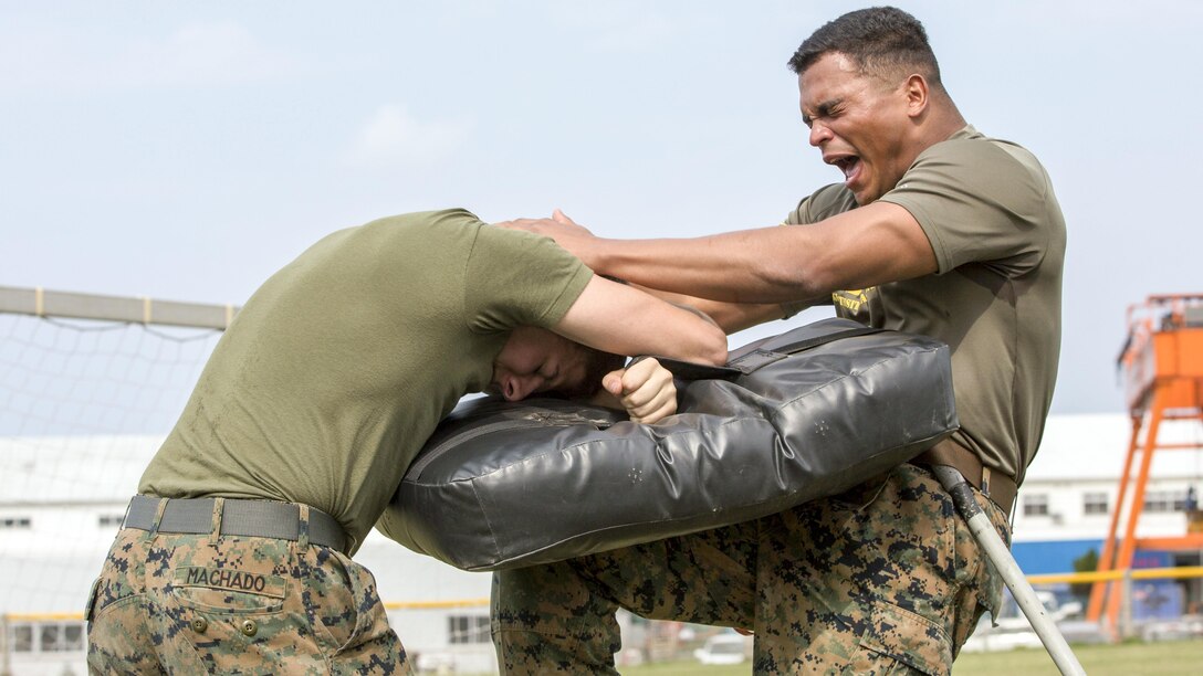 A Marine strikes a punching bag after being sprayed with pepper spray during a security augmentation force training course at Camp Kinser, Okinawa, Japan, April 14, 2017. The Marine is assigned to Headquarters and Support Battalion, Marine Corps Installations Pacific. Marine Corps photo by Lance Cpl. Christian J. Robertson