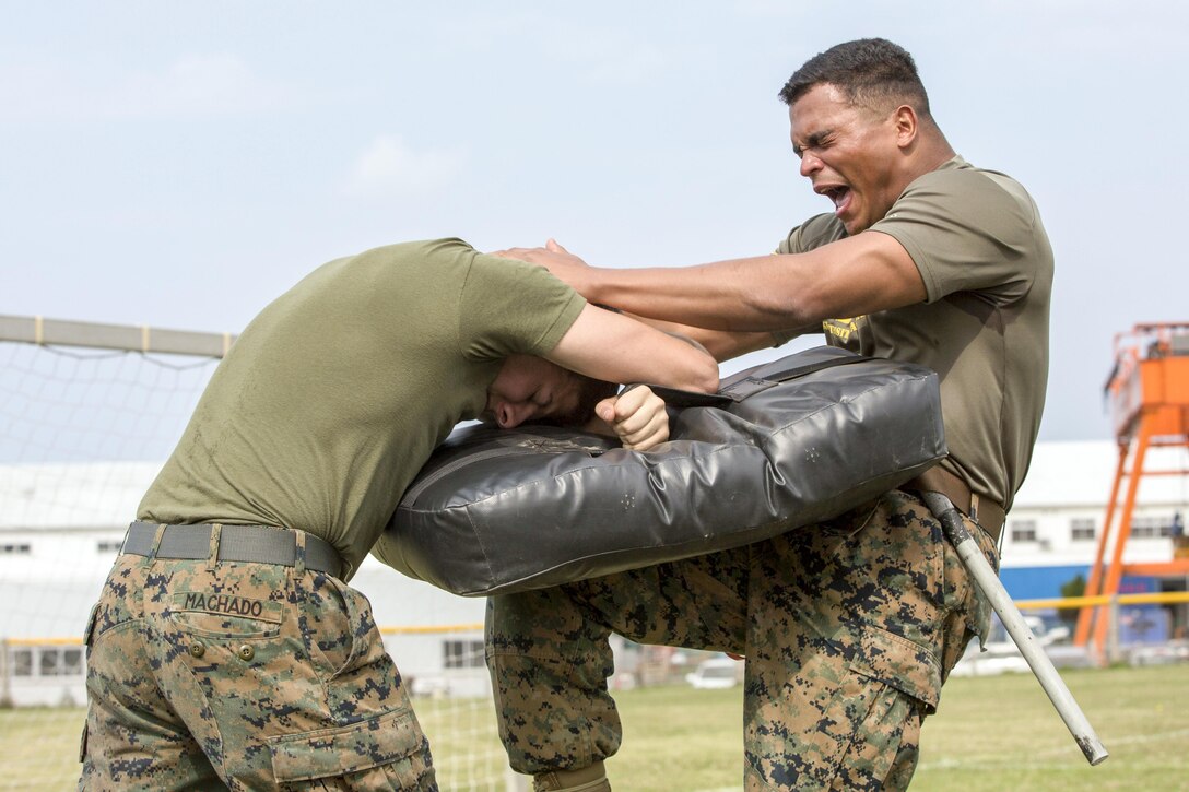 A Marine strikes a punching bag after being sprayed with pepper spray during a security augmentation force training course at Camp Kinser, Okinawa, Japan, April 14, 2017. The Marine is assigned to Headquarters and Support Battalion, Marine Corps Installations Pacific. Marine Corps photo by Lance Cpl. Christian J. Robertson