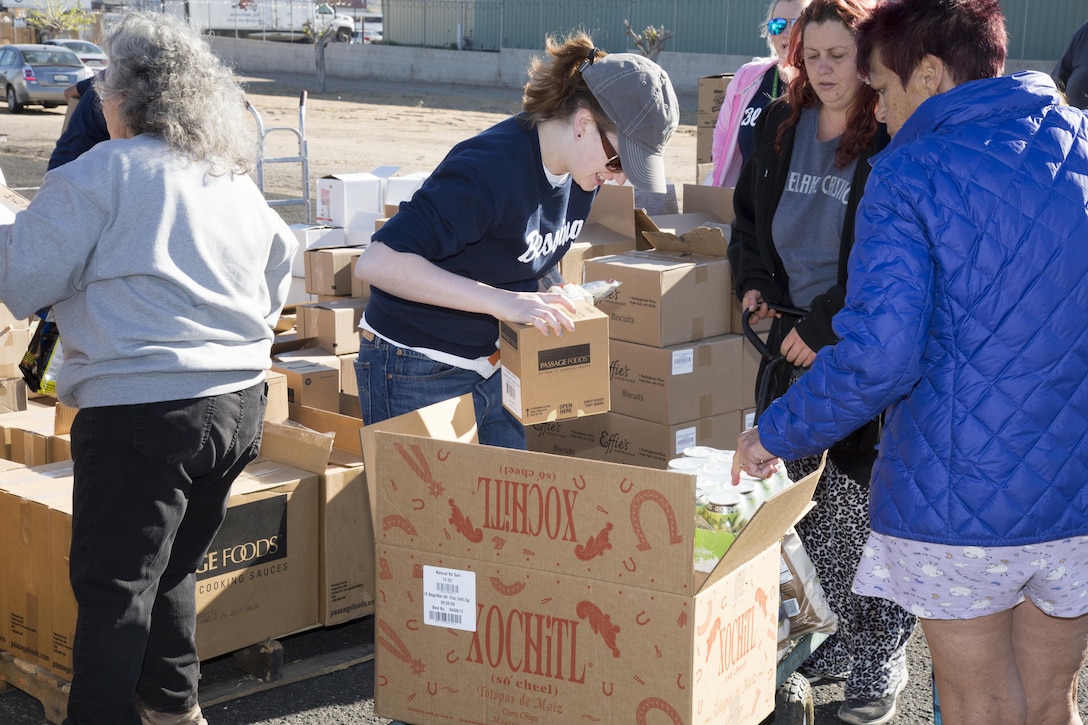 (Left) Ashley Shokorzadeh volunteers her time handing out food to more than 300 families from Barstow and surrounding communities March 24. The event was staged on the grounds of Bethany Christian Fellowhip Church in Barstow.