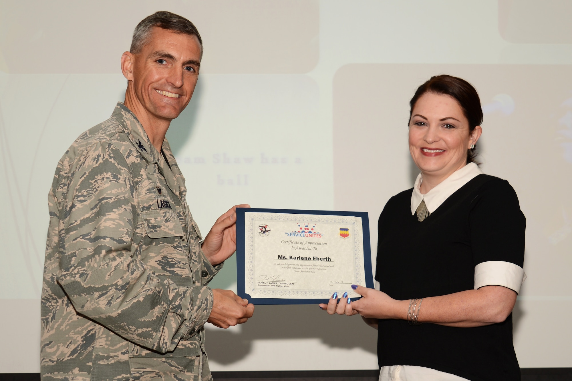 U.S. Air Force Col. Daniel Lasica, 20th Fighter Wing commander, presents Karlene Eberth, 20th Force Support Squadron McElveen Library Information and Learning Center volunteer, with a certificate of appreciation at Shaw Air Force Base, S.C., April 13, 2017. Eberth was recognized for her contributions to the library youth programs, such as summer and winter story times, and assistance to library aids which has saved the Air Force approximately $5,000 in salaries. (U.S. Air Force photo by Airman 1st Class Kathryn R.C. Reaves)