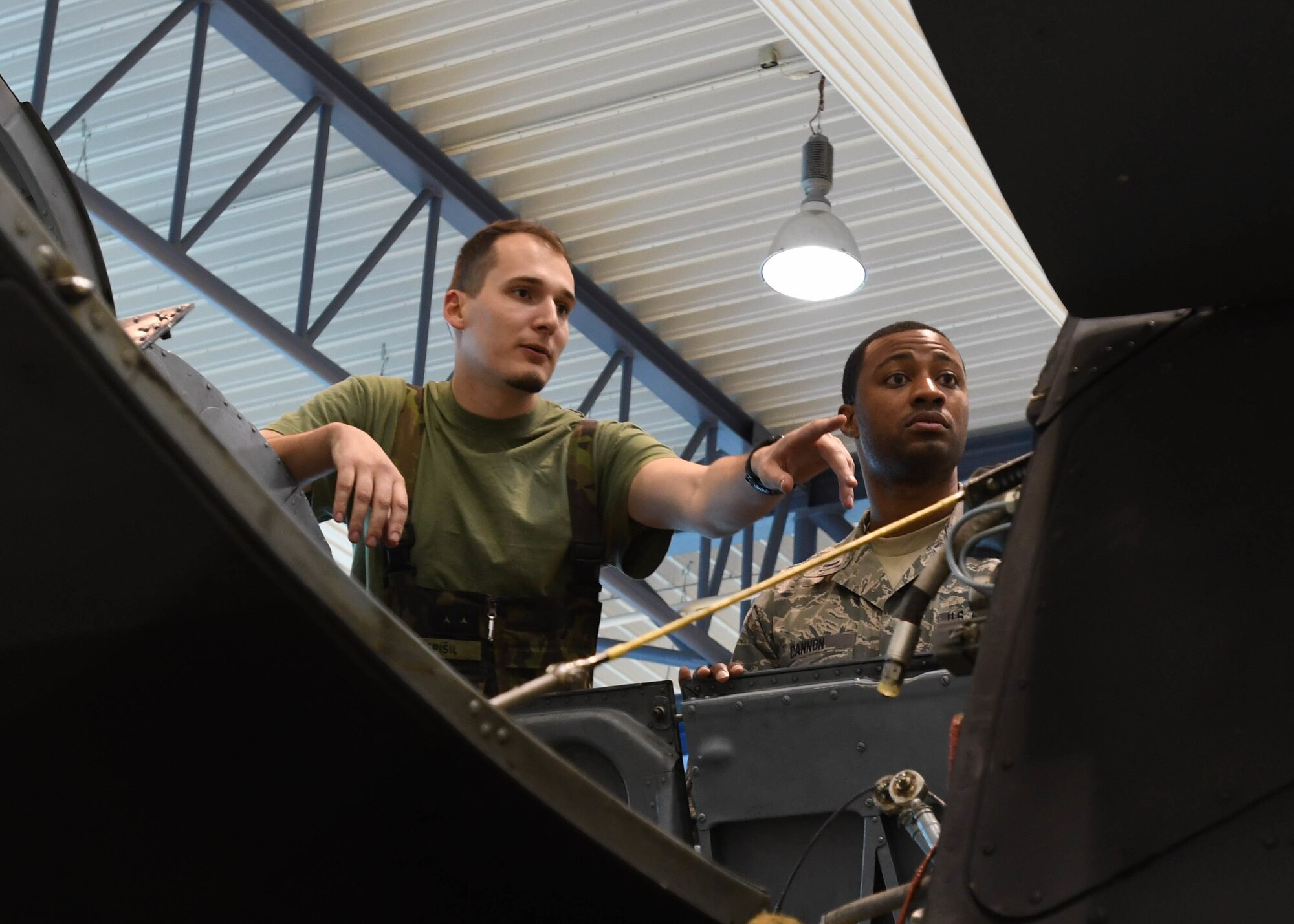 U.S. Air Force 1st Lt. Tyson Cannon, maintenance operations officer with the 149th Fighter Wing, Texas Air National Guard, and Czech Air Force 1st Lt. Pavel Popspisil, chief of electric and special equipment group, examines the main gear box of the Mi-24 Hind Attack Helicopter March 22, 2017 at 22nd Air Base, Namest Nab Oslavou, Czech Republic. Popspisil explained how the gear box and engine were configured and removed. (Air National Guard photo by Senior Airman De’Jon Williams)