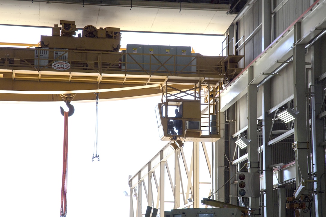 A PBB employee sits in the operating cab of the main crane in building 573, the largest freestanding structure in the Marine Corps. The crane, operated by the Material Handling Equipment section, is easily capable of lifting and moving a nearly 70 ton Abrams main battle tank to any section of building 573 at Production Plant Barstow, Marine Depot Maintenance Command, aboard the Yermo Annex of Marine Corps Logistics Base Barstow, Calif.