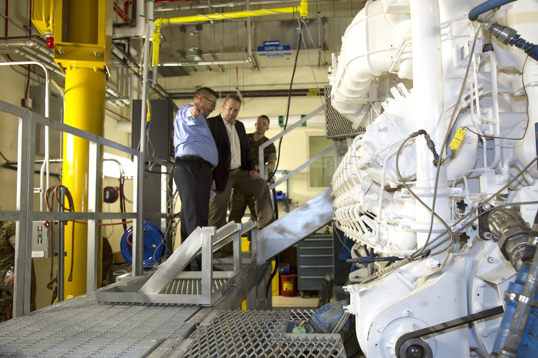 (Left) William Beckley, production trades manager, explains how the testing on the Paxman engine works to Bryan H. Wood, assistant deputy commandant, Installations and Logistics. Coast Guard cutters use two to four of the huge engines to power the craft. Wood visited Marine Corps Logistics Base Barstow and Production Plant Barstow, Marine Depot Maintenance Command, aboard the Yermo Annex of MCLB Barstow, April 5.