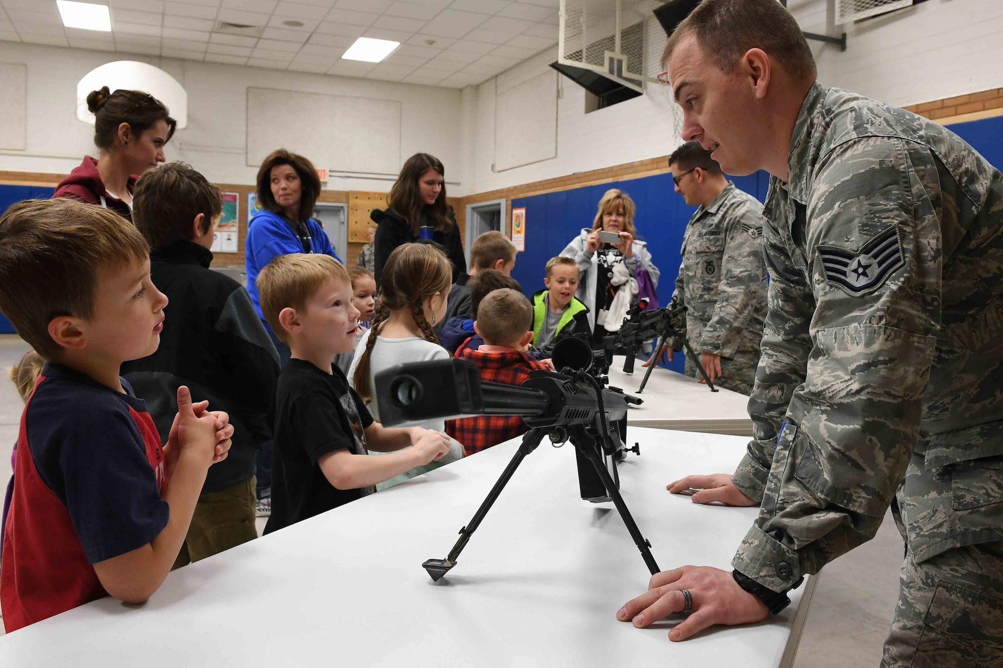 Staff Sgt. Ajay Rivera, 75th Security Forces Squadron combat arms instructor, shows children some military weapons during the Kids Deployment Day event, Hill Field Elementary School, Utah, April 4, 2017. (U.S. Air Force photo/R. Nial Bradshaw)