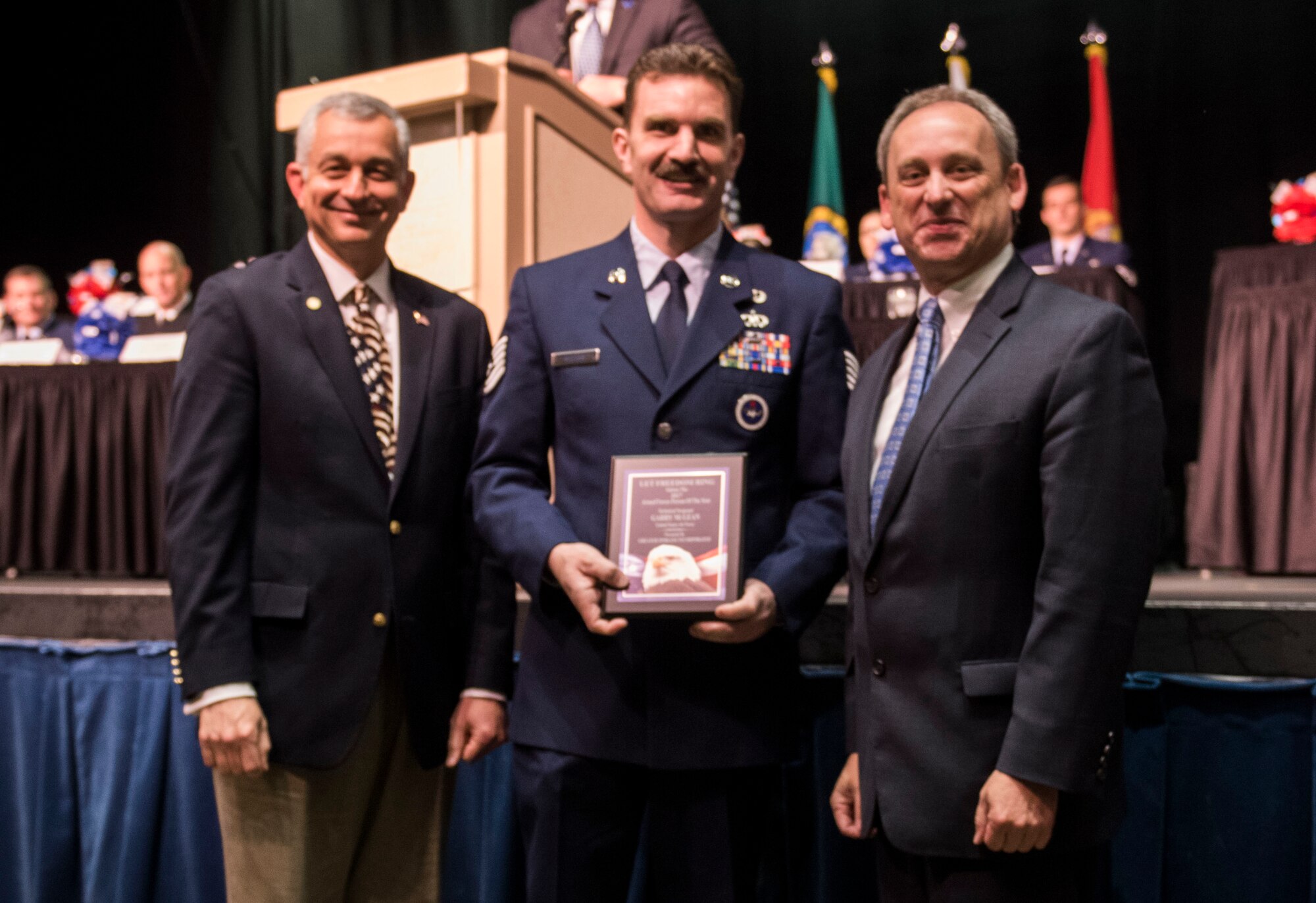 Tech. Sgt. Garry Mclean, 336th Training Support Squadron curriculum development NCO in charge, receives the 2017 Armed Forces Persons of the Year award, category Guard/Reserve E-1 through E-4, from Todd Mielke, Greater Spokane Incorporated CEO, and retired Brigadier General Roger Watkins, during the 61st annual Let Freedom Ring breakfast April 14, 201, at Northern Quest Casino in Spokane, Washington. The event honored military members from all branches, and recognized the Armed Forces Persons of the Year. (U.S. Air Force photo/Airman 1st Class Sean Campbell)