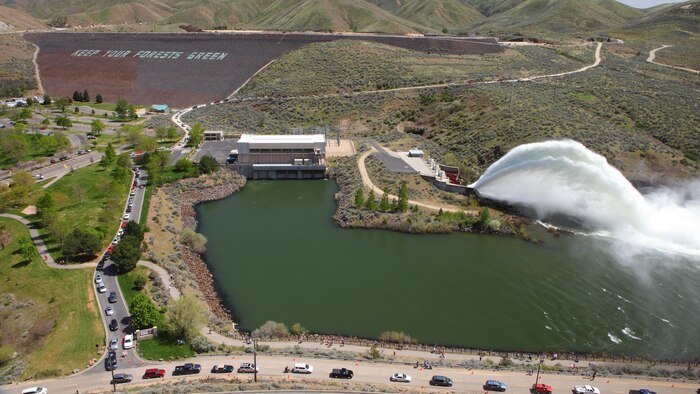 View of the "Rooster Tail", Lucky Peak Dam, April 29, 2012, Boise, Idaho. A popular springtime attraction is the "Rooster Tail" which results from the discharge of water through the original release structures of the dam under pressure from the lake above.  Using a "flip bucket" to direct the spray high into the air, the erosive, scouring force of the water is greatly dissipated as it rises, rests and slowly falls back to the stream channel.
The Rooster Tail only uses water from large releases required for flood risk management that exceed powerhouse capacity, thus no water is wasted for the display.   
It occurred daily until 1986 when construction of the Lucky Peak Power Plant Project started.  